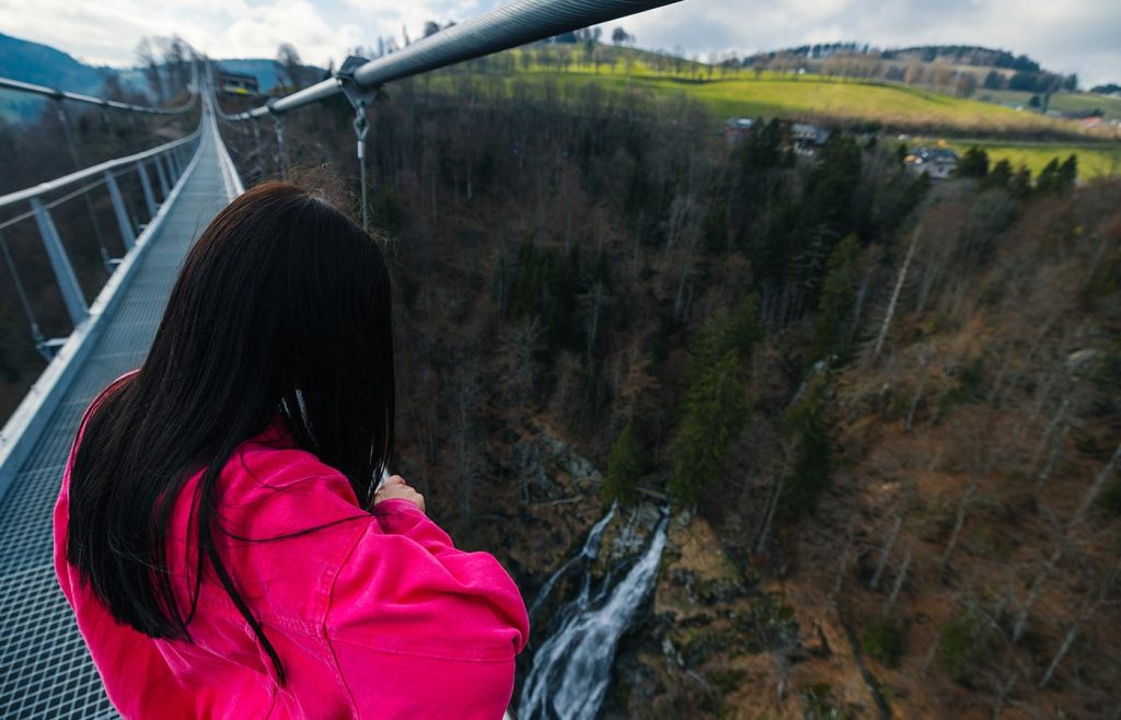 Besucherin schaut schaut sich den Wasserfall von der BLACKFORESTLINE aus an